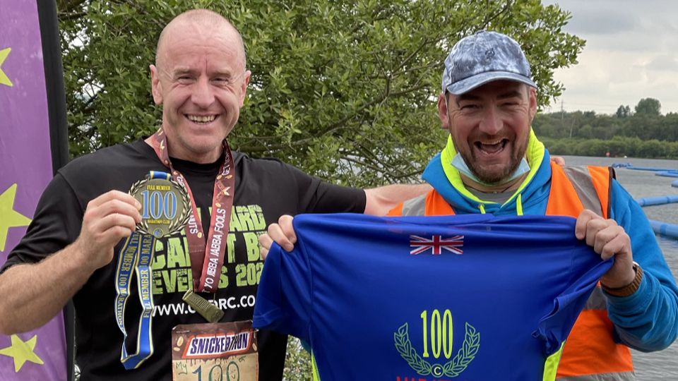 Stephen Hayes is presented with his 100 marathon t-shirt at The Snickerthon event