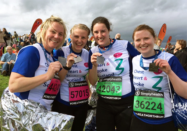Four happy ladies in CHSS tops with medals at EMF 