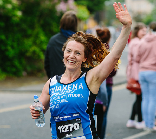 A happy runner waves at Edinburgh Marathon