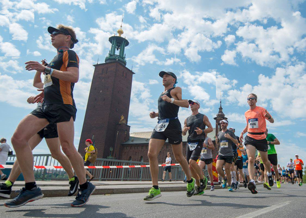 runners under a blue skies with puffy little clouds at Stockholm Marathon